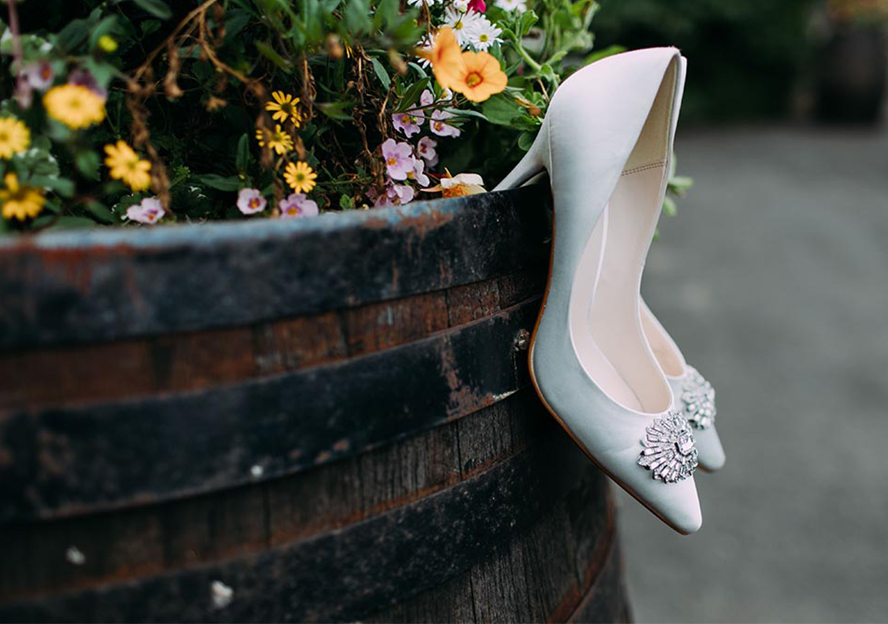 Brides shoes hanging from a wooden planter