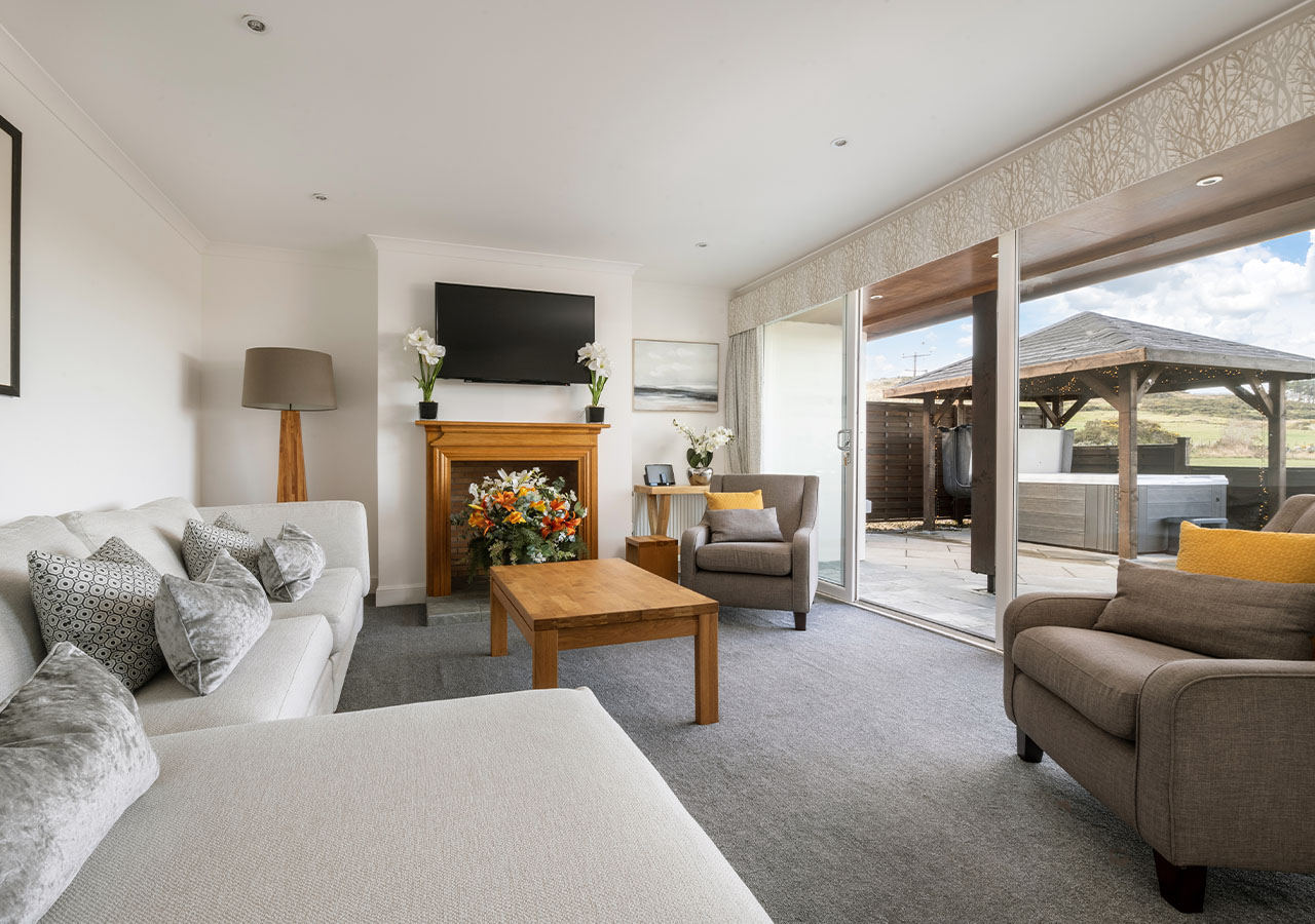 The bright airy living room with patio doors onto the patio with a hot tub at Elderburn Luxury Lodges