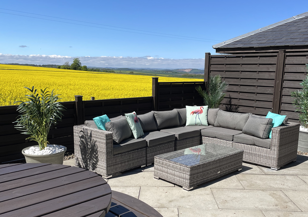 Outdoor seating patio area with picnic table and fields in the background